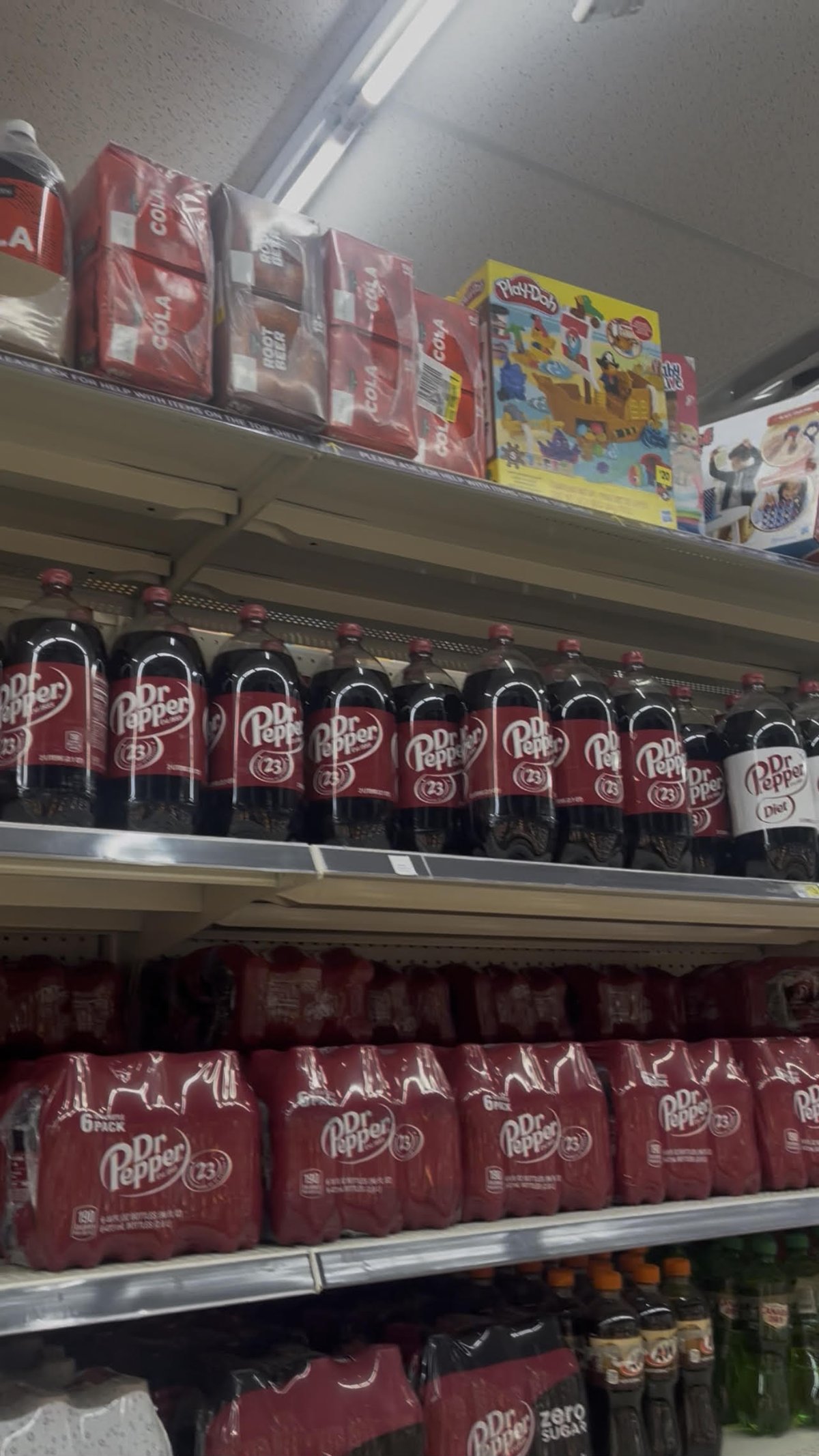 Clover Valley Cola and Root Beer 12 pack cases on the top sky shelf above the soda aisle at Dollar General